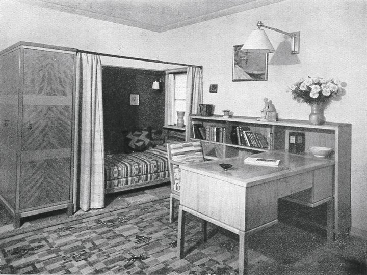 Schwarzweiss Bild eines Schlafzimmers mit Schreibtisch aus den 20er Jahren.